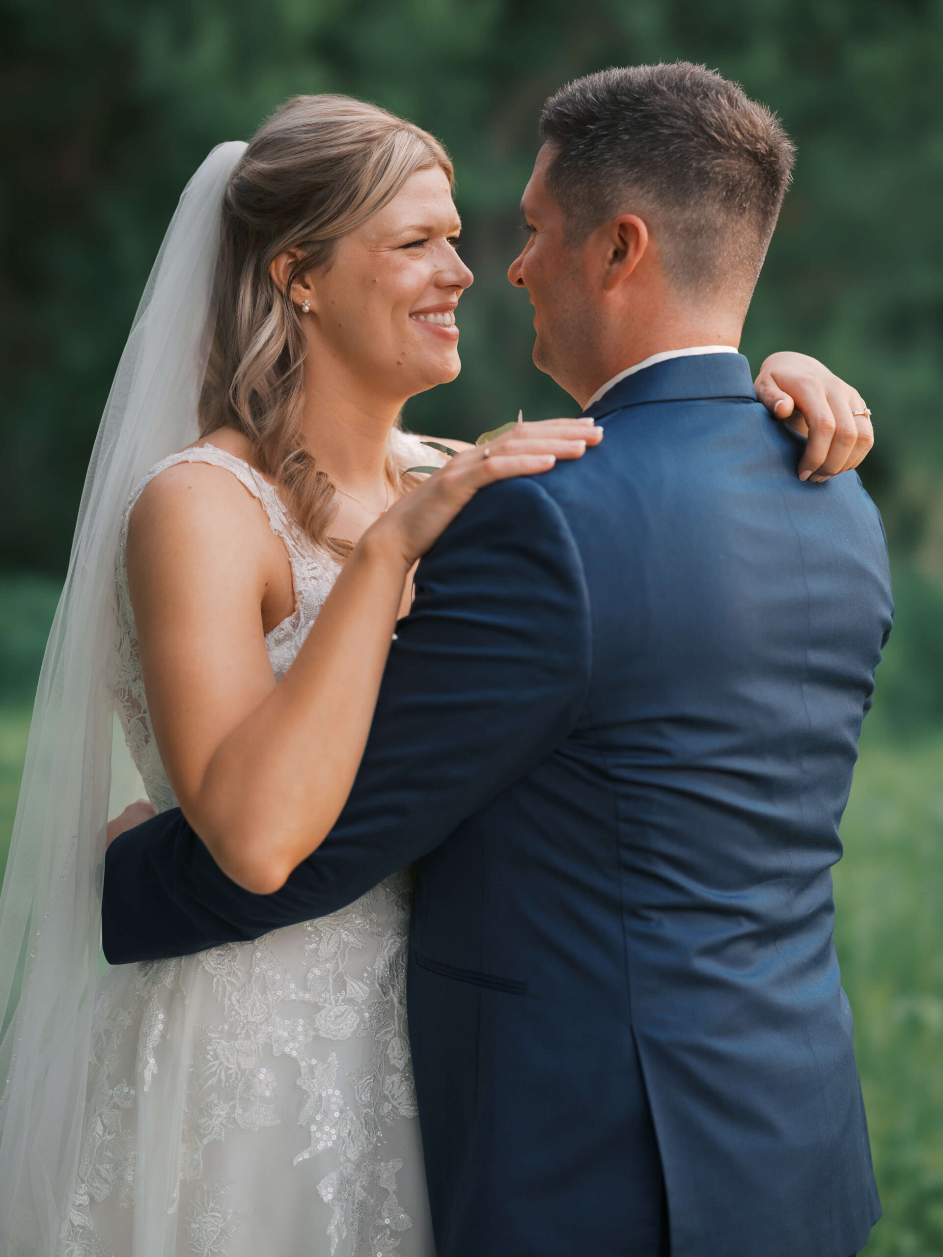 A bride and groom dance and smile at each other in the lawn of the Hillcrest Country Club wedding venue