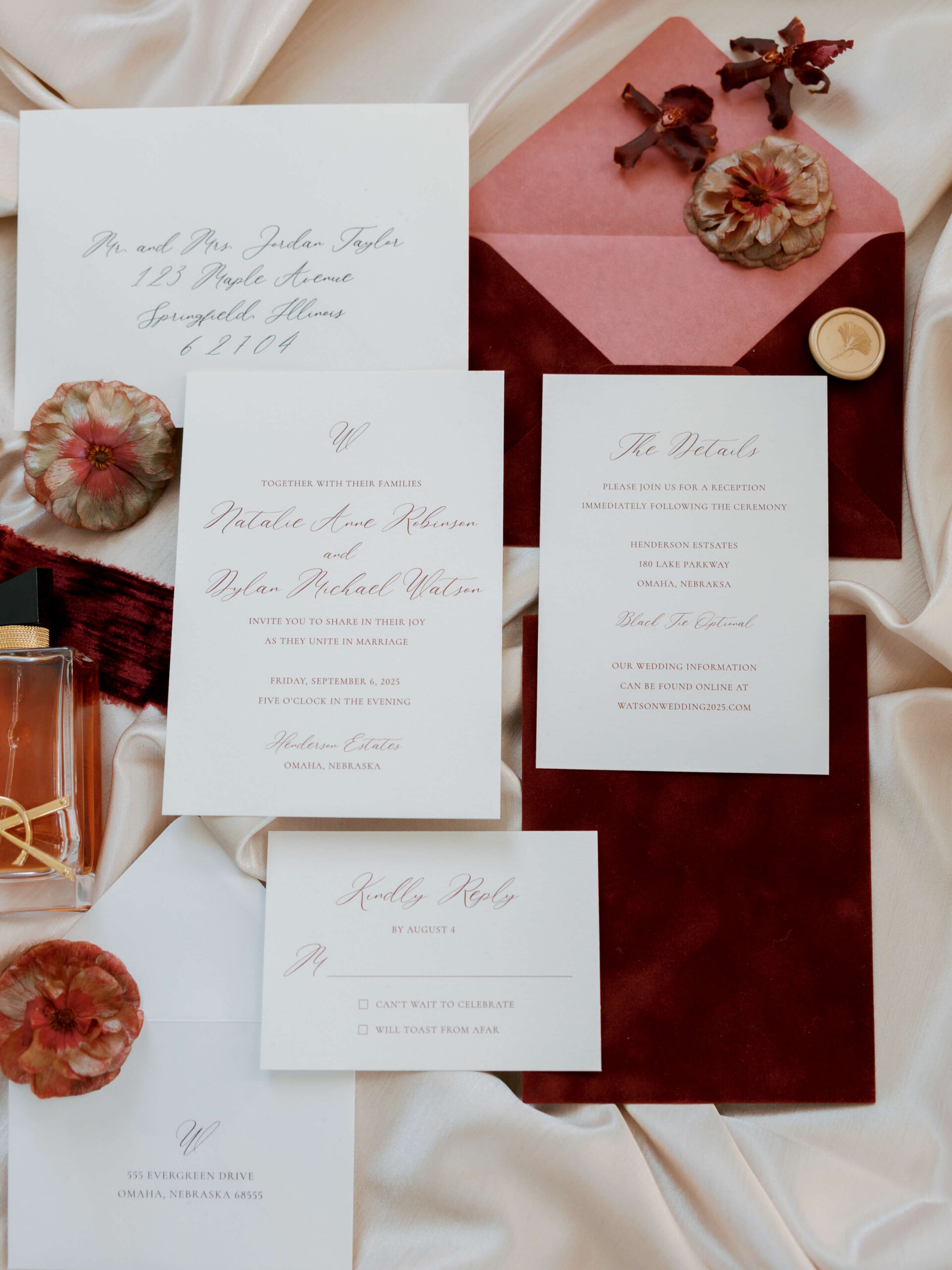 Details of wedding invitations with dark red flowers and perfume