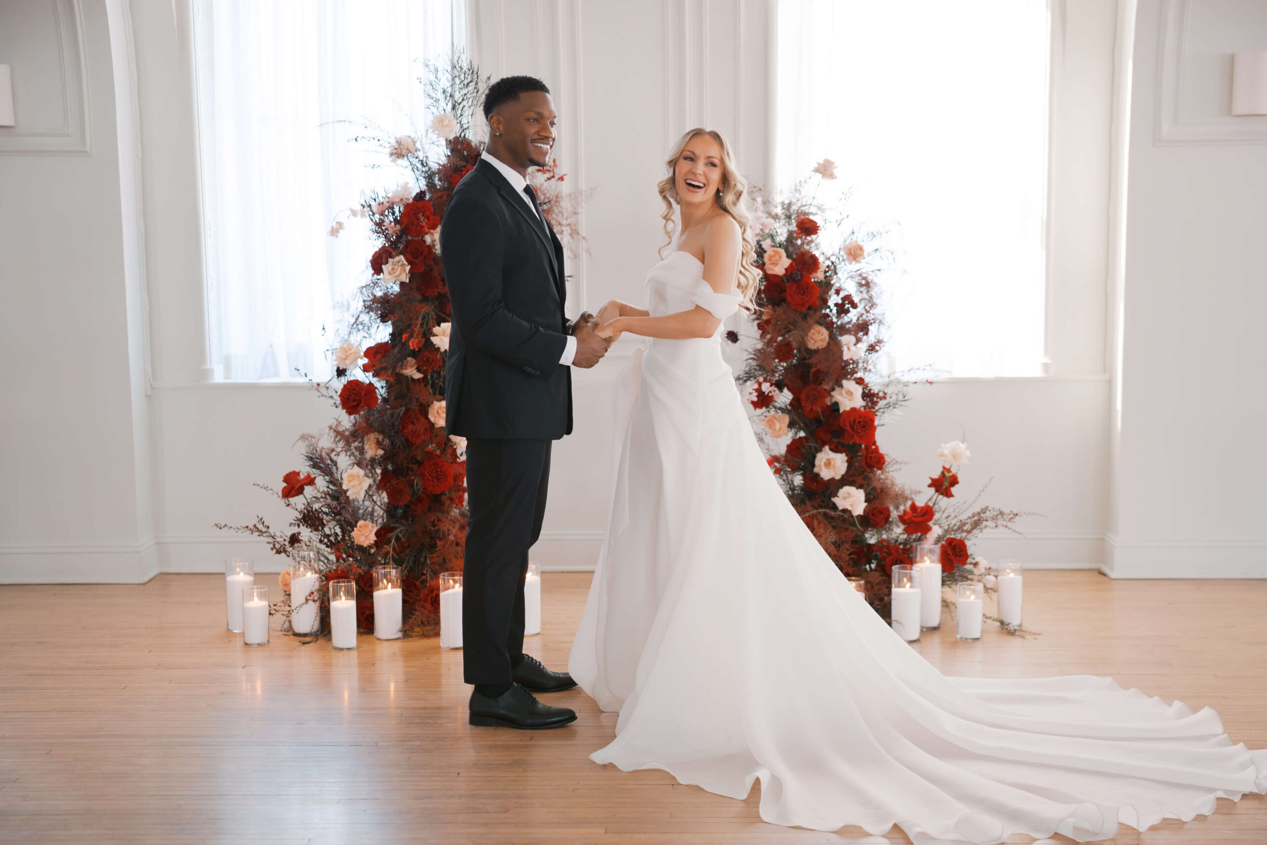 A bride and groom laugh during their cottonwood hotel wedding ceremony and holding hands