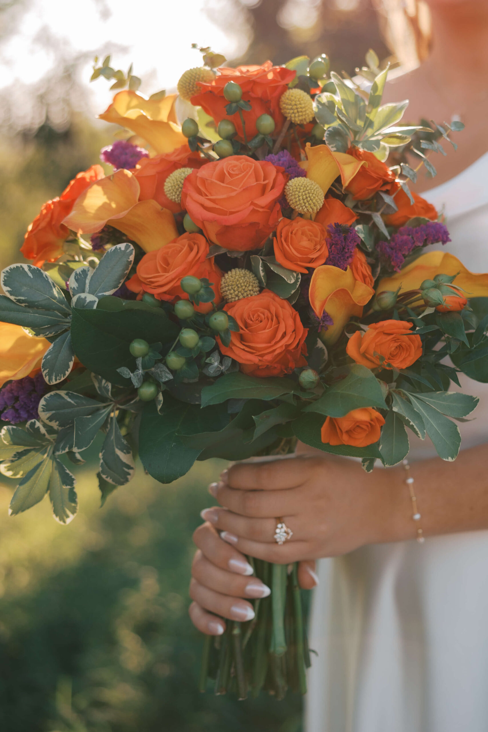 Details of a bride's vibrant and colorful orange based bouquet