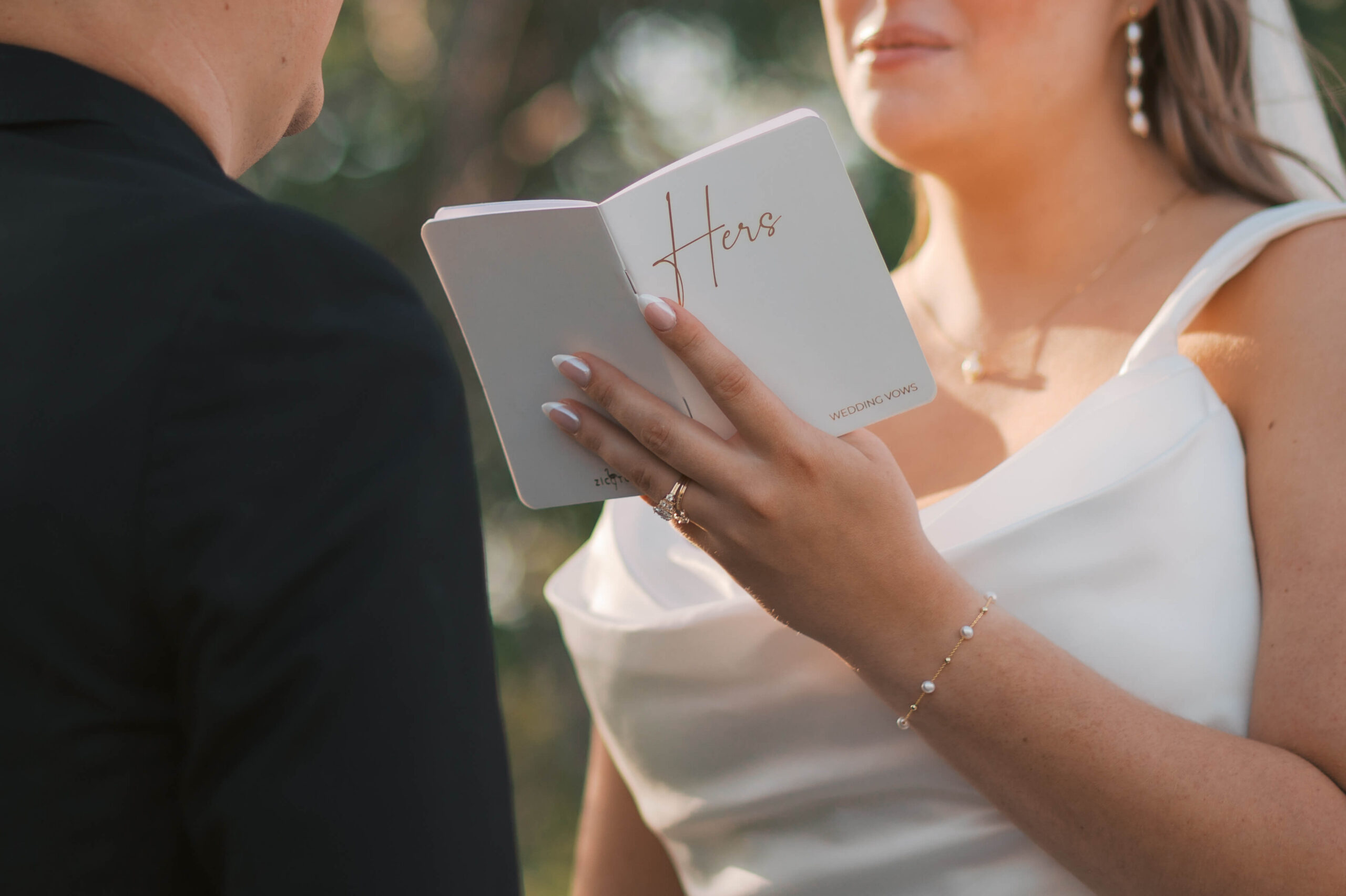 Details of a bride holding and reading her wedding vows in the sun during their glacial till vineyard wedding