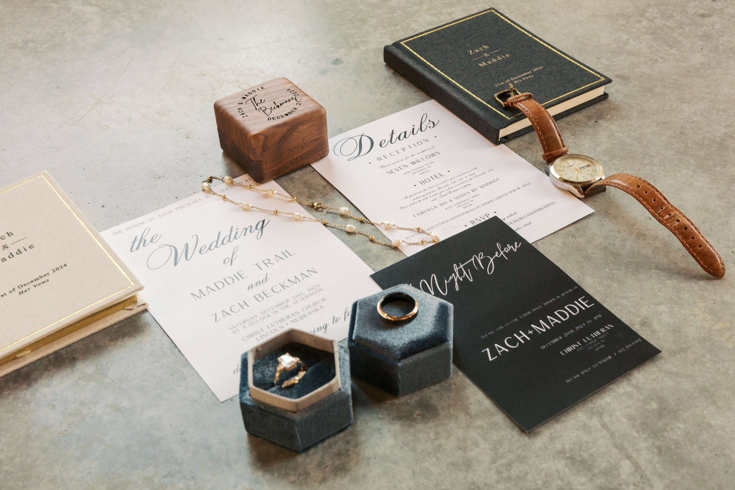 Groom details including rings, wooden ring box and watch with invitations
