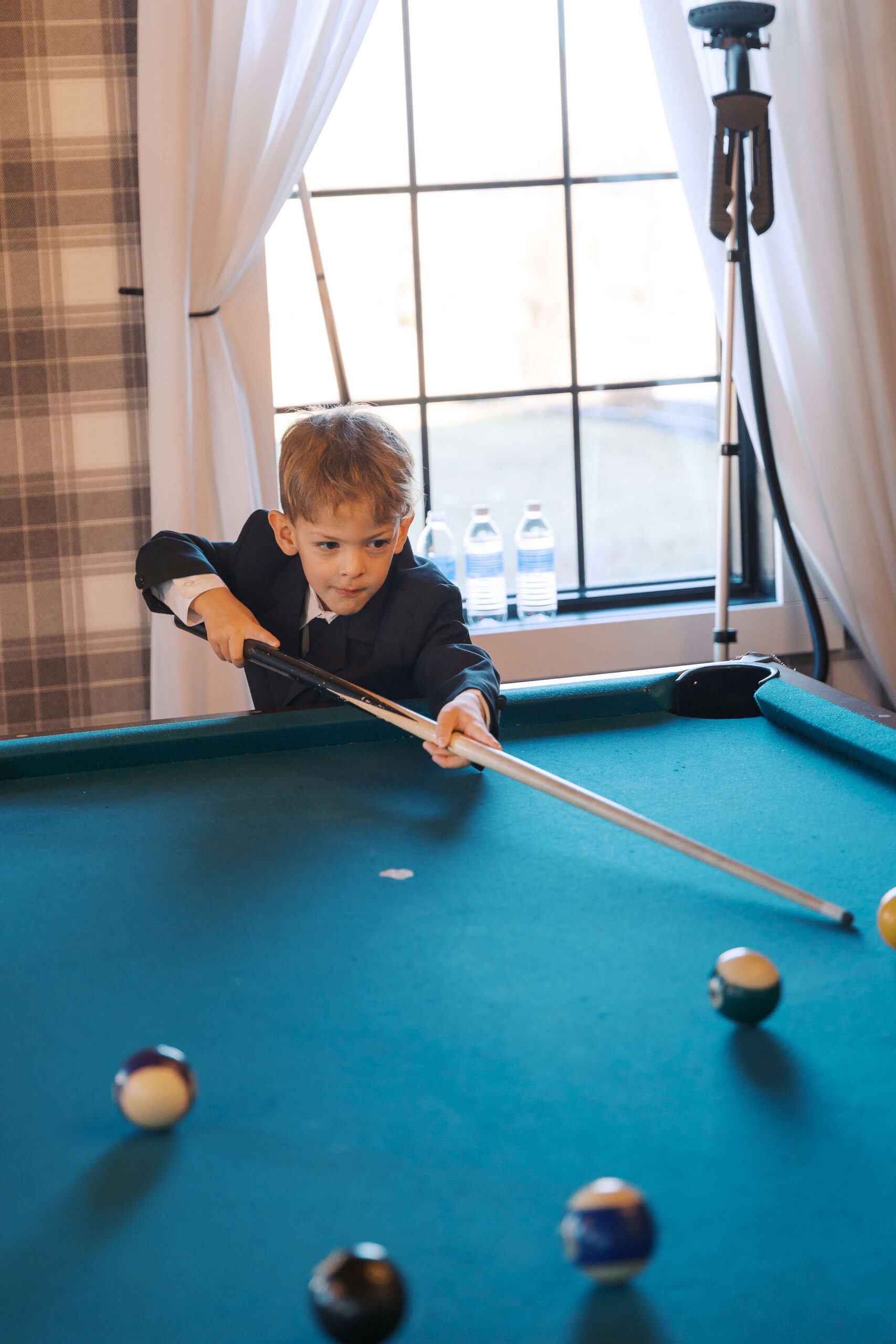 A young boy aims a pool shot