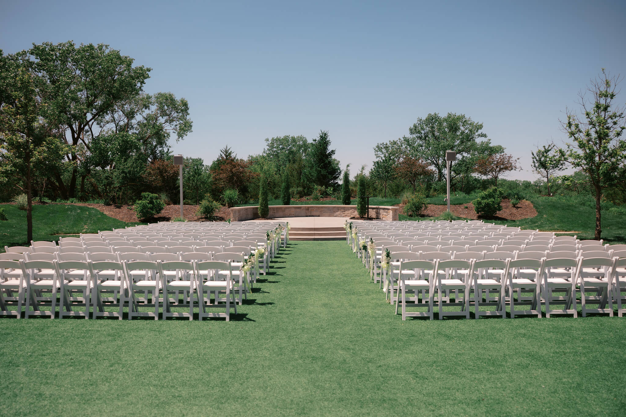 A look at an empty ceremony at The Acreage wedding venue with white chairs in the gardens