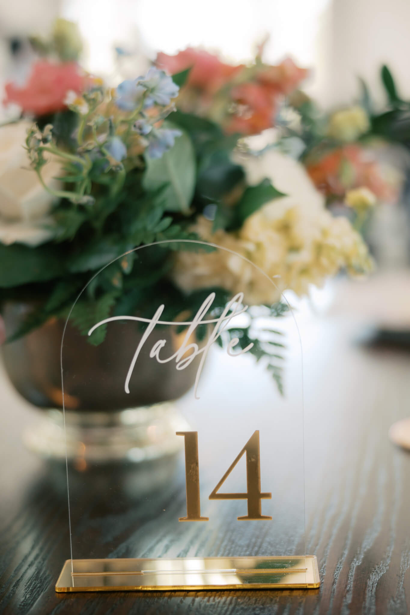 Details of a glass and gold wedding reception table number