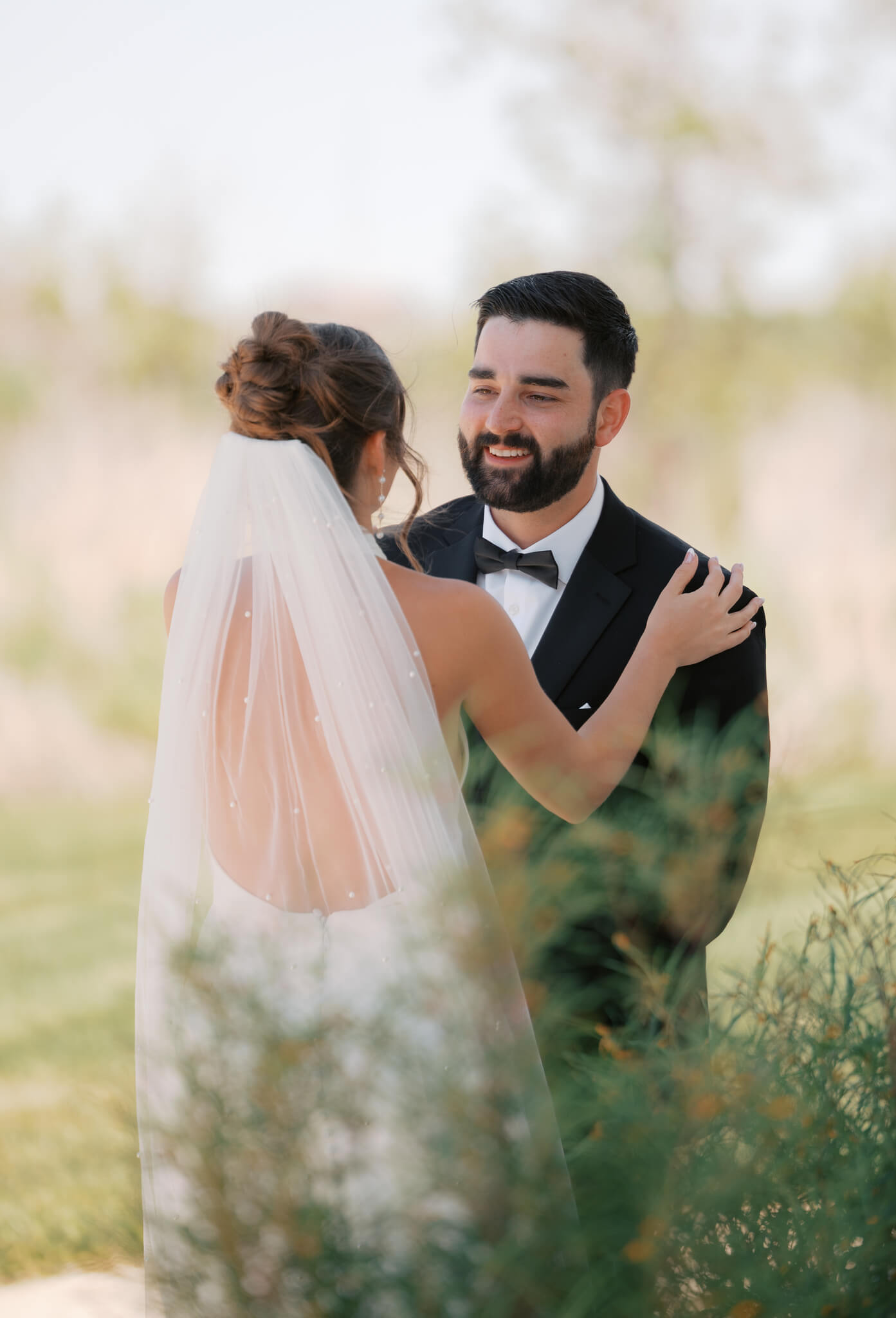 A bride and groom enjoy their first look in a garden
