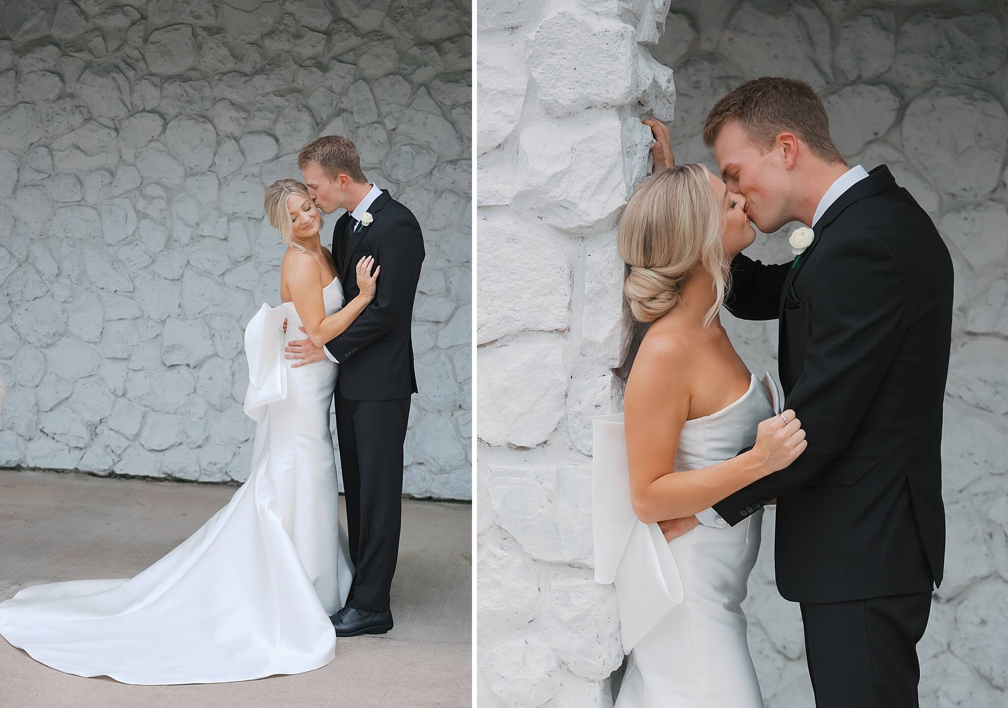 Newlyweds kiss against white stone walls of The Fountains Ballroom wedding venue