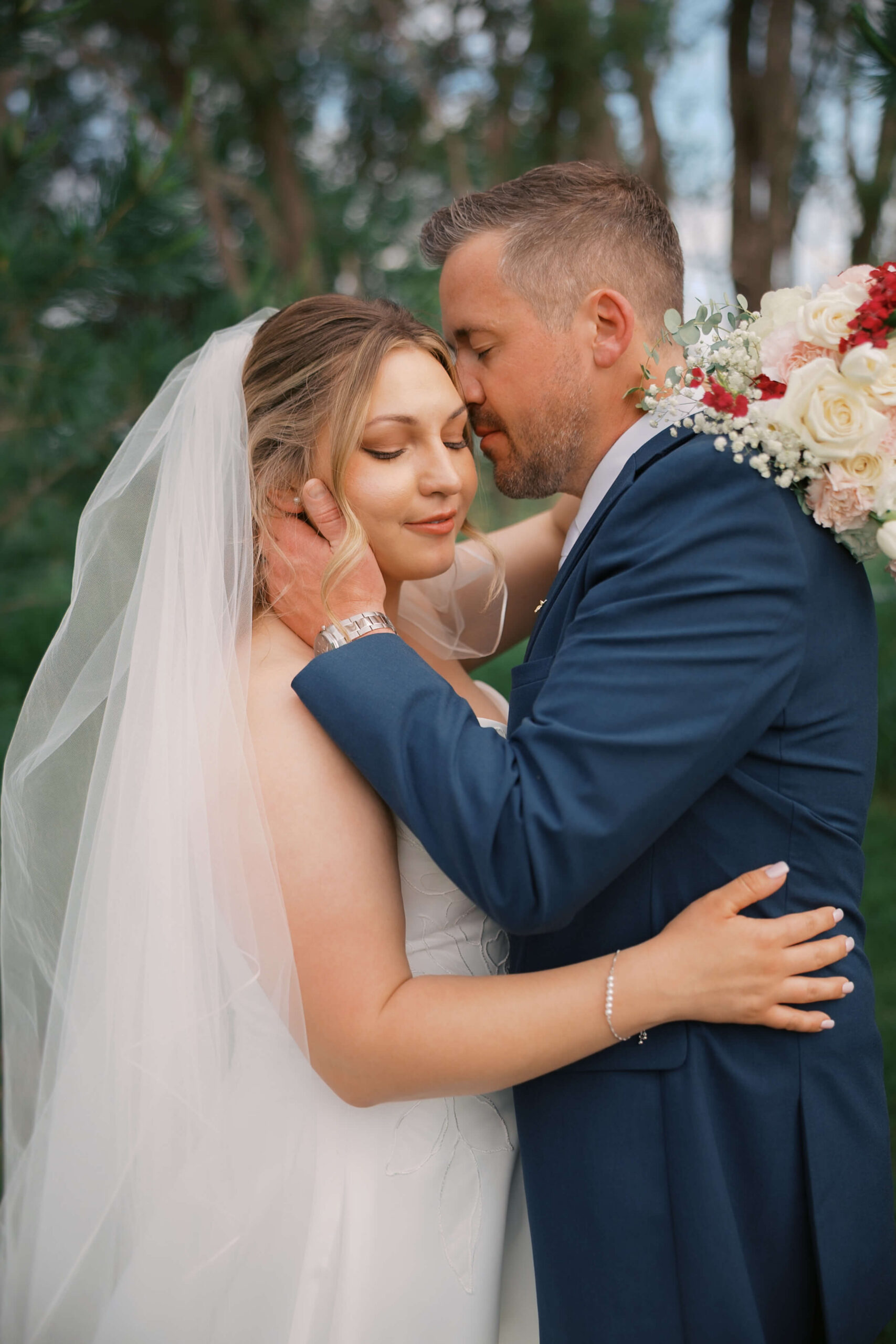 A bride and groom snuggle in a special moment at sunset during their bosana wedding