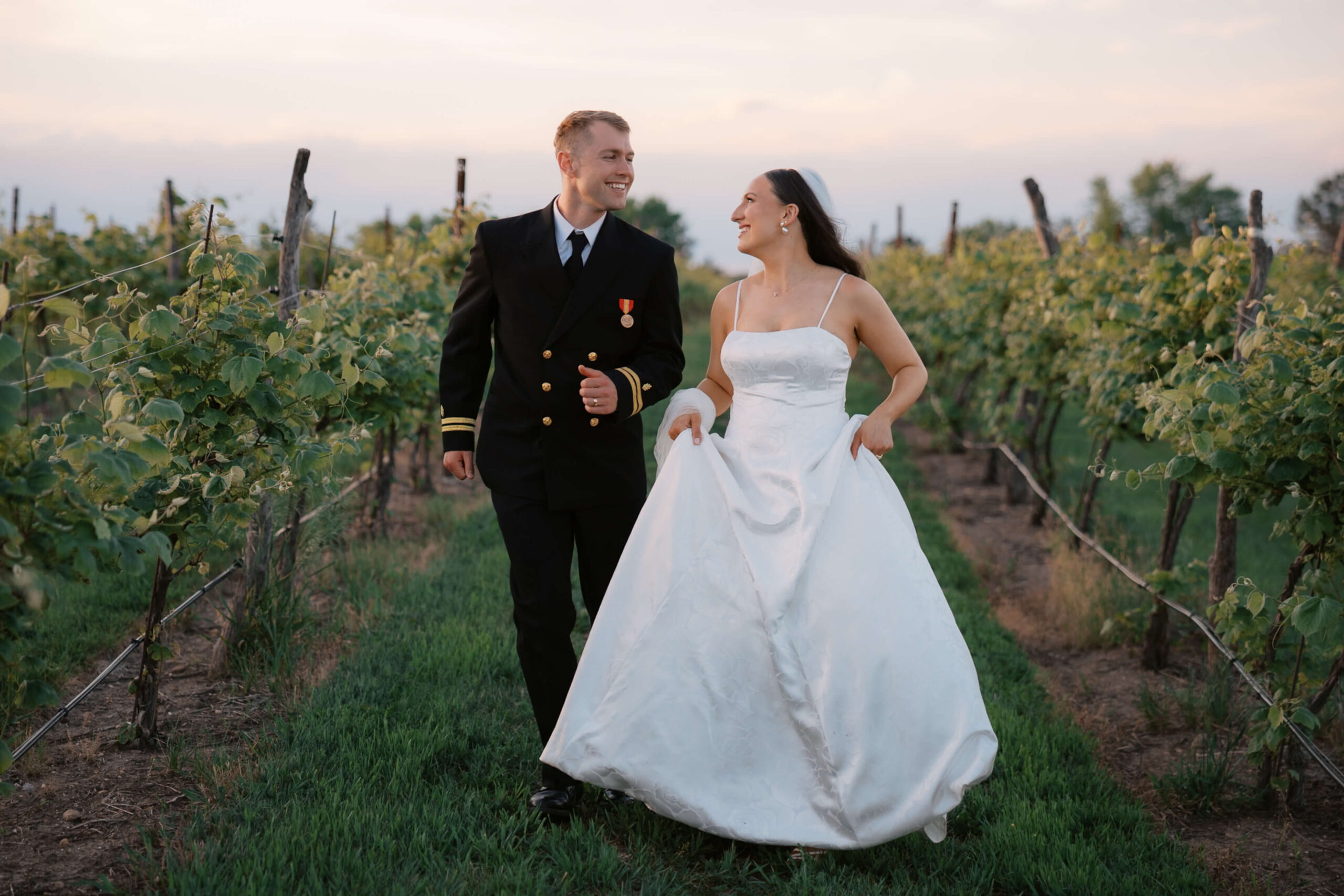 Happy newlyweds explore a vineyard at one of the lincoln wedding venues