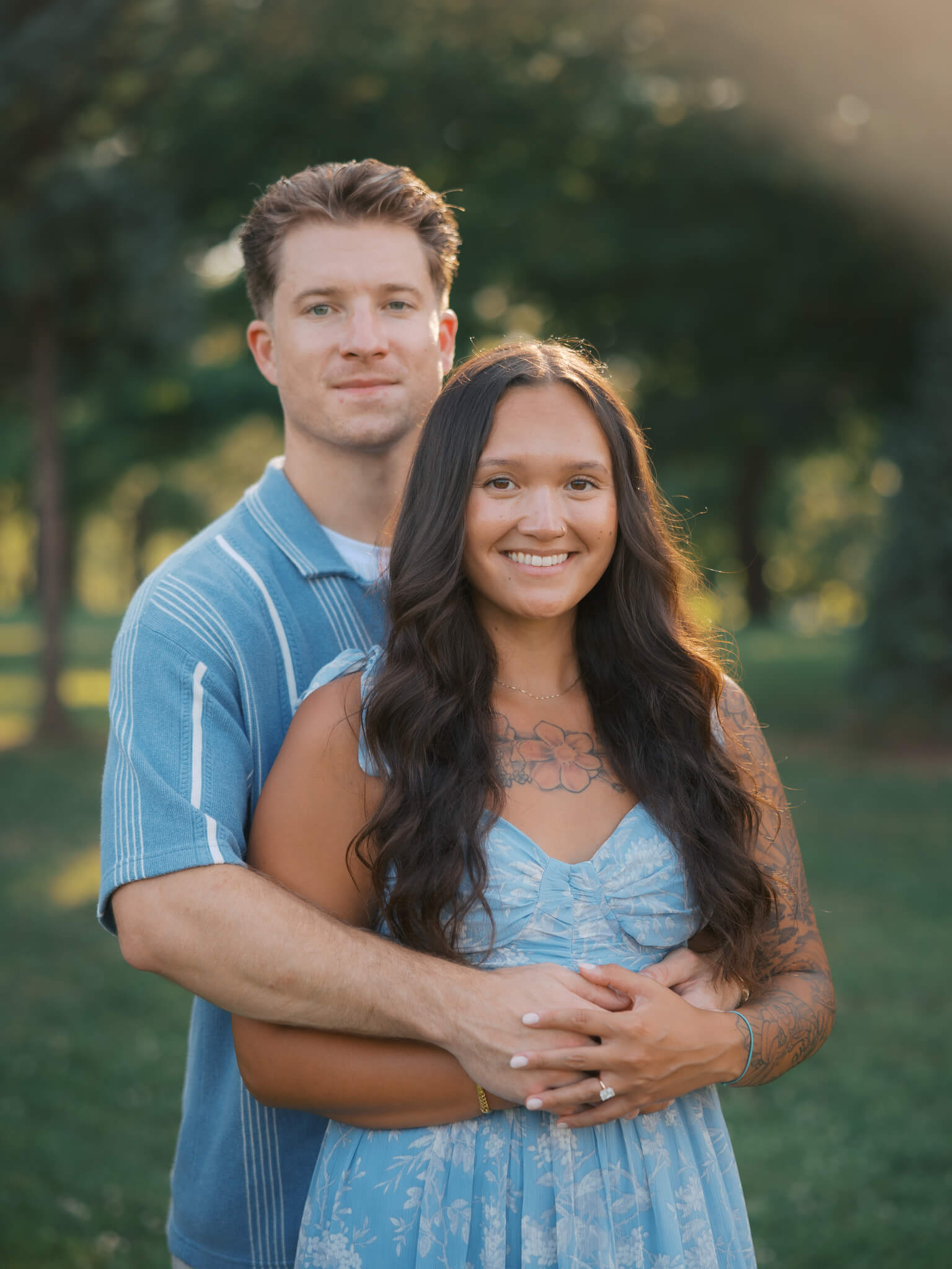 A happy woman is hugged from behind by her fiancee
